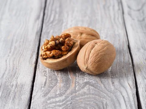 Walnut with shell on wooden background. Stock Photos
