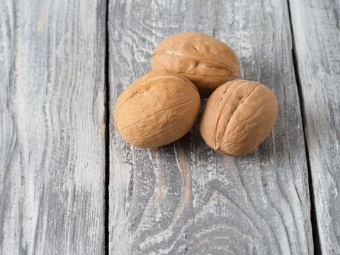 Walnut with shell on wooden background. Stock Photos