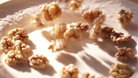 Walnut. walnut close up. Walnuts fall in slow-motion shot on a white plate. Slow Stock Footage 87704321