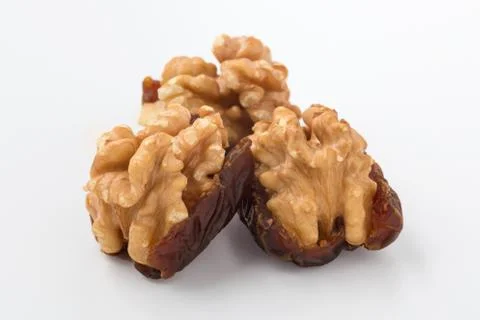 Walnuts and dates on white background, closeup Stock Photos