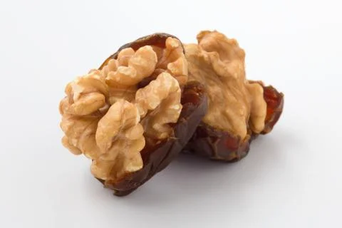 Walnuts and dried date fruit on white background, closeup Stock Photos