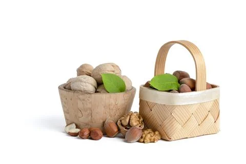 Walnuts and hazelnuts of different varieties lie in wooden saucers and baskets Stock Photos