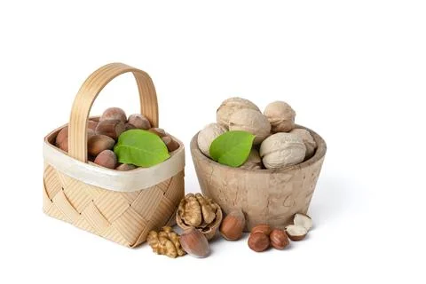 Walnuts and hazelnuts of different varieties lie in wooden saucers and baskets Stock Photos