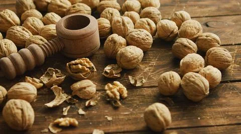 Walnuts and nutcracker on table Closeup shot of fresh walnuts and wooden t... Stock Photos