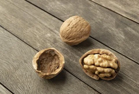 Walnuts and open nut over a wooden table Stock Photos