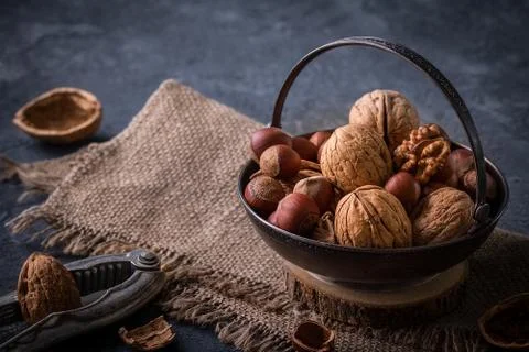 Walnuts and pine nuts on dark stone table Stock Photos