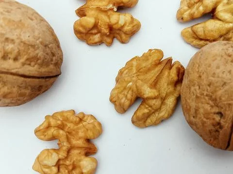 Walnuts and walnut kernels on white background flat lay Stock Photos