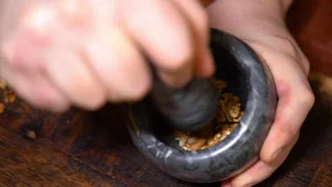 Walnuts are ground in a mortar, close-up Stock Footage 249055102