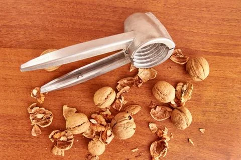 Walnuts are split with a nutcracker. Kitchen appliances for work in the kit.. Stock Photos