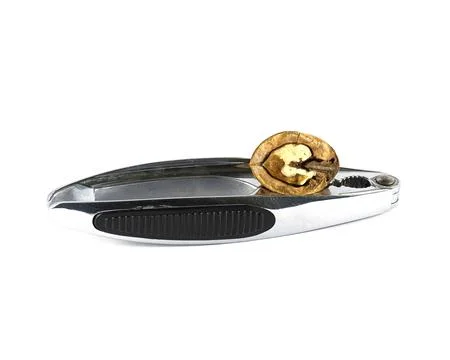 Walnuts are split with a nutcracker. Kitchen appliances for work in the kitchen. Stock Photos