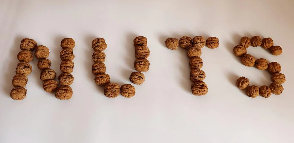 Walnuts arranged in the word "NUTS" Stock Photos