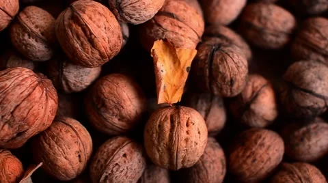 Walnuts with Autumn Leaves and Plum on Brown Background Видео 59086920