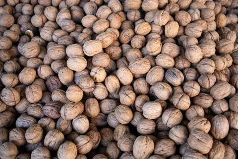 Walnuts background, texture. Dried nuts whole with shell on market display, t Stock Photos