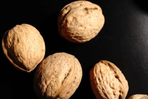 Walnuts on a black background. The light was dim. Stock Photos