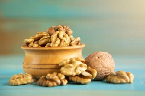 Walnuts on blue rustic table in wooden bowl Foto stock