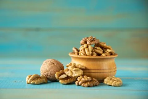 Walnuts on blue rustic table in wooden bowl Foto stock