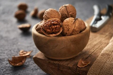 Walnuts in a bowl. The process of splitting nuts. Rustic style. Stock Photos