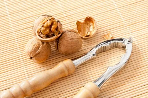Walnuts with broken shell and nutcracker Stock Photos