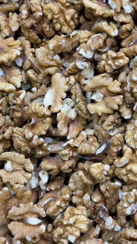 Walnuts in close-up form a textured background, ideal for culinary and heal.. Stock Footage 336208357