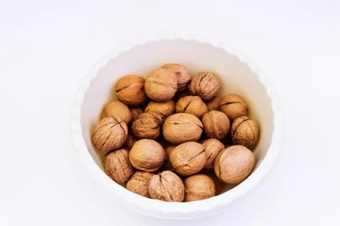 Walnuts in a cup on a white background Stock Photos