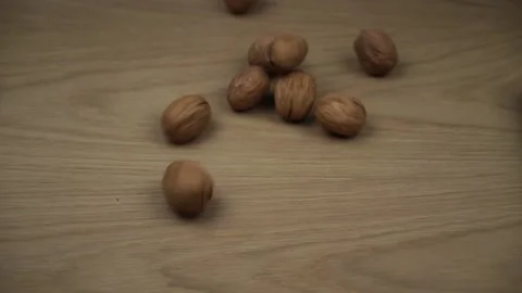 Walnuts Fall And Fill Screen. Walnuts rolling on wooden background. Slow motion. Stock Footage 130918403