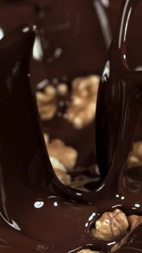 Walnuts fall into liquid chocolate. Filmed on a high-speed camera at 1000 fps Stock Footage 335380940