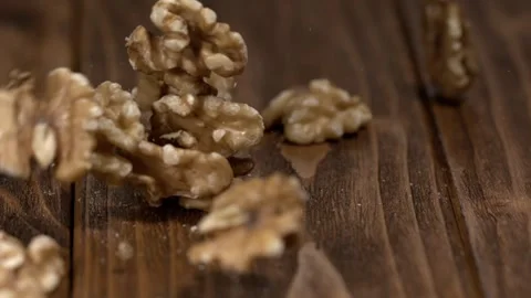 Walnuts fall on wooden surface during preparation for cooking in kitchen Stock Footage 323147678