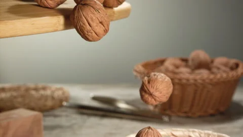 Walnuts falling from a cutting board in slow motion Stock Footage 152175976
