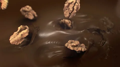 Walnuts Falling Into Liquid Chocolate in 4K Super slow motion Видео 141080022