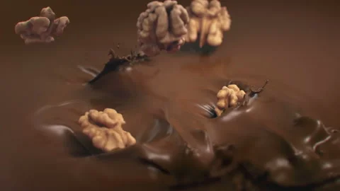 Walnuts Falling Into Liquid Chocolate in 4K Super slow motion Stock Footage 141080084