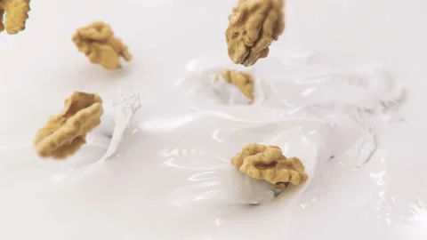 Walnuts Falling Into Milk in 4K Super slow motion Stock Footage 141073851