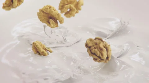 Walnuts Falling Into Milk in 4K Super slow motion Stock Footage 141074453