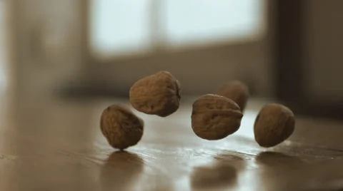 Walnuts falling on wooden table. Slow Motion. Stock Footage 50504105
