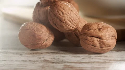 Walnuts falling on a wooden table in slow motion Stock Footage 152175466