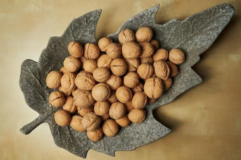 Walnuts on a felt backing in the form of a maple leaf Stock Photos