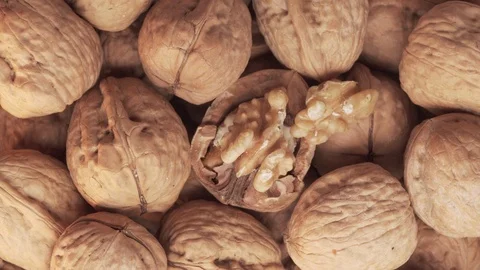 Walnuts group and cracked walnut turning. Top view Video stock 124858292