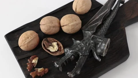 Walnuts kernel, shell and nutcracker rotating with wooden cutting board Video stock 139114271