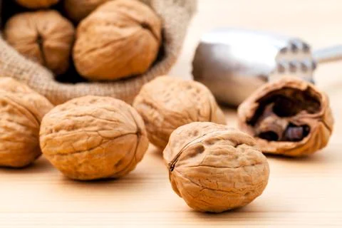 Walnuts kernels and whole walnuts on wooden background. Whole and chopped wal Stock-Fotos
