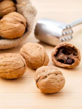 Walnuts kernels and whole walnuts on wooden background. Whole and chopped wal Stock Photos