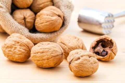 Walnuts kernels and whole walnuts on wooden background. Stock Photos