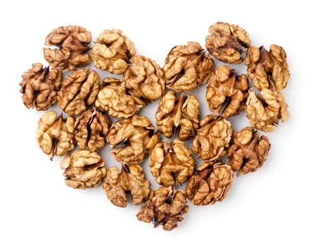 Walnuts kernels lined with hearts on a white background. Top view Stock Photos