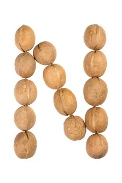 Walnuts lined in the shape of the letter "N" isolated on white Stock Photos