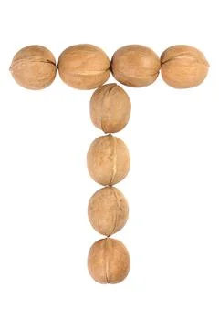 Walnuts lined in the shape of the letter "T" isolated on white Stock Photos