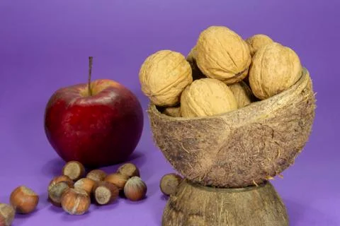 Walnuts in natural coconut shell cup and apple Stock Photos