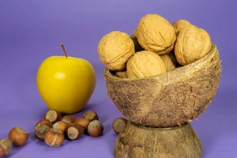 Walnuts in natural coconut shell cup and apple Stock Photos