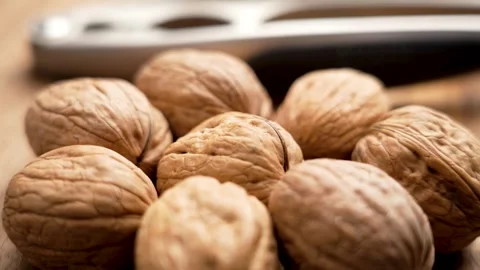 Walnuts with nutcracker on wooden table Video stock 303853800
