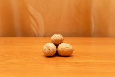 Walnuts on the orange table. Golden background, much space around Stock Photos