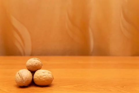 Walnuts on the orange table. Golden background. Walnuts are in the corner Stock Photos