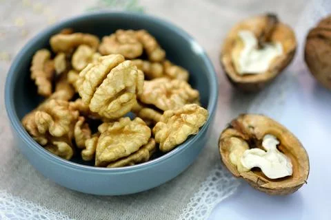 Walnuts peeled and in shell on a tablecloth on the table Stock Photos