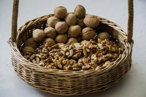 Walnuts peeled and in shells on a table in a basket. Stock Photos